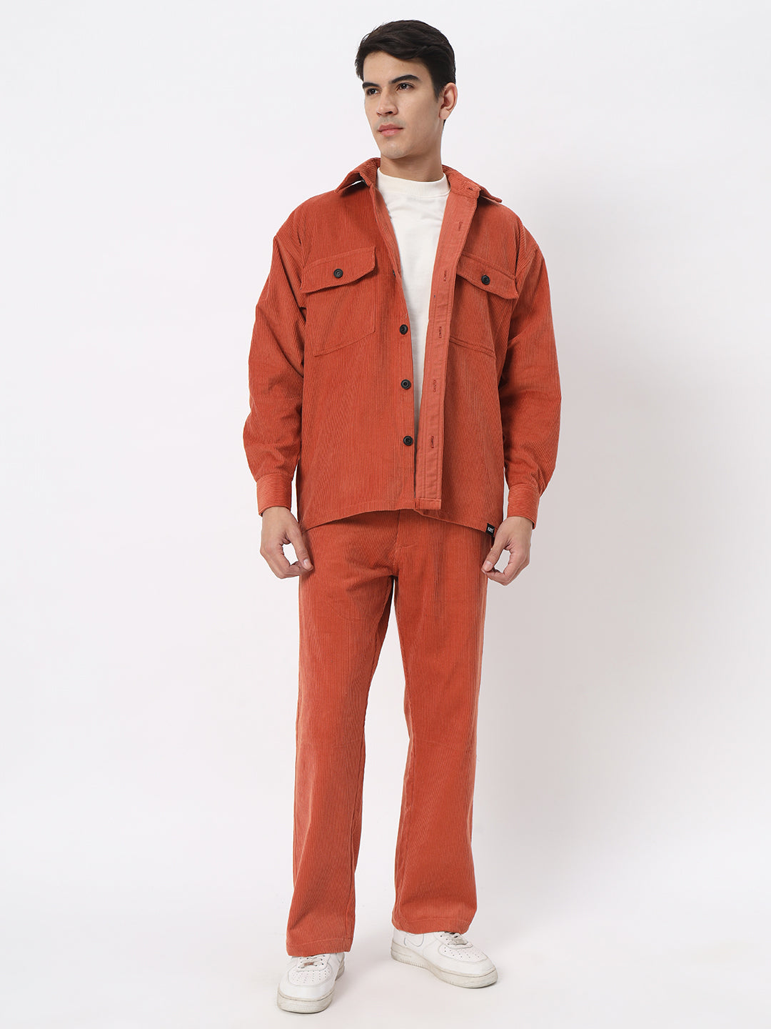 a man in a red suit standing in front of a wall