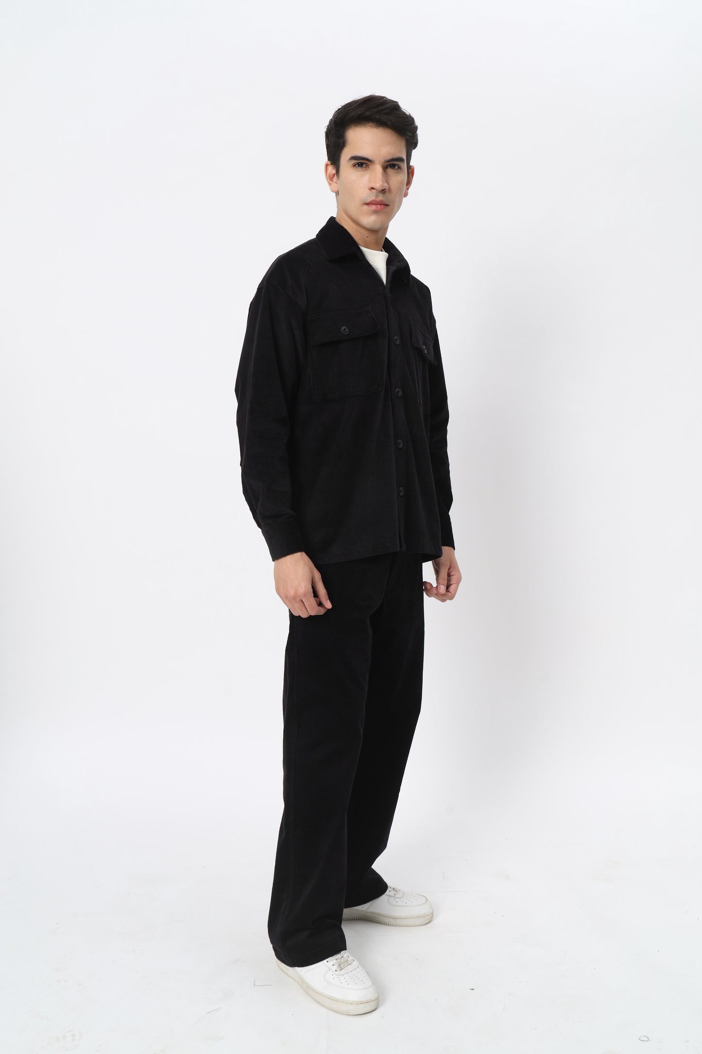 a man in a black jacket standing on a skateboard